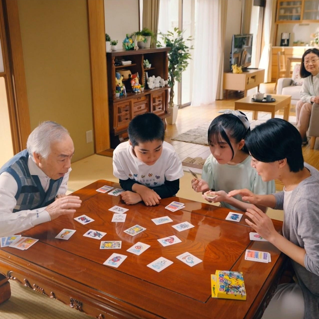 Family playing a board game together in a cozy living room.